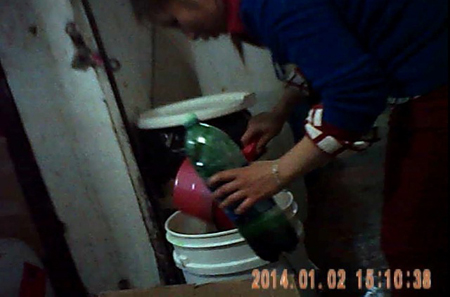 Người nhân viên vừa đánh máy nhãn sản phẩm, lấykéo cắt, chuẩn bị dán lên thân chai tinh dầu.