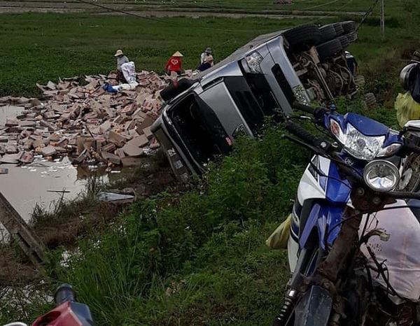Tin tức - Hình ảnh đẹp: Xe container bị lật, người dân Phú Yên giúp tài xế đưa hàng trăm lon nước lên bờ