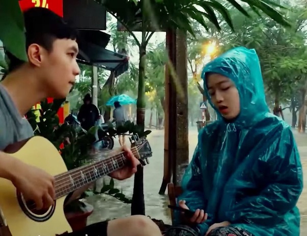 Cộng đồng mạng - Cô gái Huế mặc áo mưa, ngồi đàn hát giữa trời mưa lũ khiến dân mạng rần rần xin 'info'