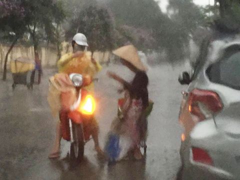 Cô gái Hà Nội dừng xe, mặc áo mưa cho cụ bà trong cơn dông - Ảnh 1