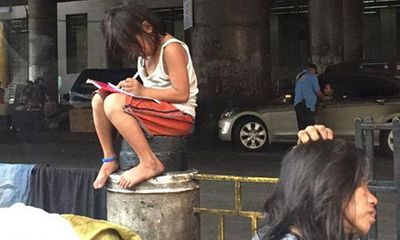 Bé gái chân trần làm bài tập trên đường gây xúc động