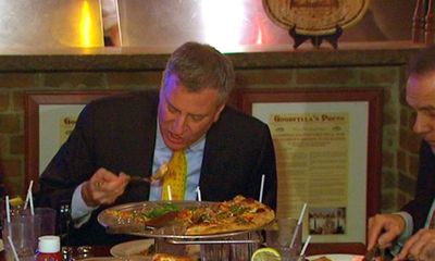 Thị trưởng New York “phạm luật” ăn bánh pizza
