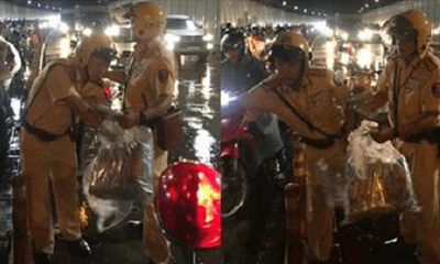 Hai chiến sĩ CSGT phát áo mưa miễn phí cho người dân trong hầm Thủ Thiêm vào đêm Trung thu