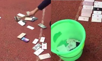 Học sinh xếp hàng xem điện thoại của mình bị đập vỡ và ngâm nước