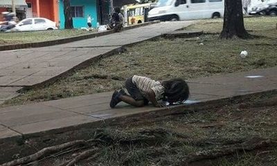Bức ảnh cô bé quỳ xuống uống vũng nước bẩn trên đường gây sốc cộng đồng thế giới