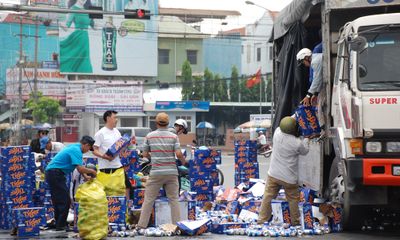 Người dân giúp tài xế thu gom hàng trăm thùng bia rơi trên đường