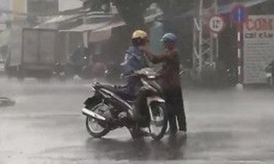 Khoảnh khắc xúc động: Bố dừng xe, chịu ướt mặc áo mưa cho con trai 30 tuổi