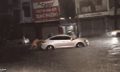 Ấm lòng khoảnh khắc chiến sỹ CSGT đội mưa lớn đẩy xe ô tô cho người dân lúc rạng sáng