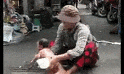 Phẫn nộ cảnh người phụ nữ ngồi giữa đường, dội nước vào đứa trẻ còn đỏ hỏn