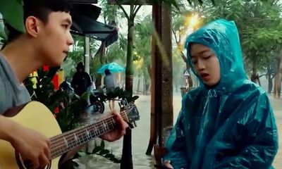 Cô gái Huế mặc áo mưa, ngồi đàn hát giữa trời mưa lũ khiến dân mạng rần rần xin 