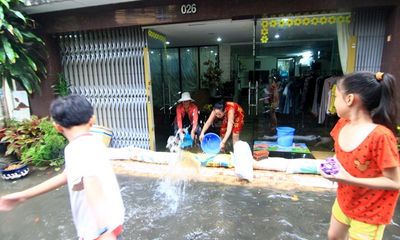 Mưa lớn, người Sài Gòn dùng máy bơm hút nước ra khỏi nhà
