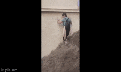Clip: Người phụ nữ quyết tâm đi xuống cầu thang khi nước lũ chảy xối xả