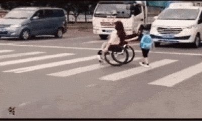 Đẩy xe lăn cho người phụ nữ khuyết tật, bé trai có hành động lịch sự gây chú ý