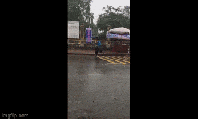 Nhan sắc nữ tình nguyện viên chạy hộc tốc cầm ô che mưa 