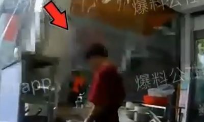 Nhân viên nhà hàng vắt nước từ giẻ lau bàn vào nồi nước nấu mì